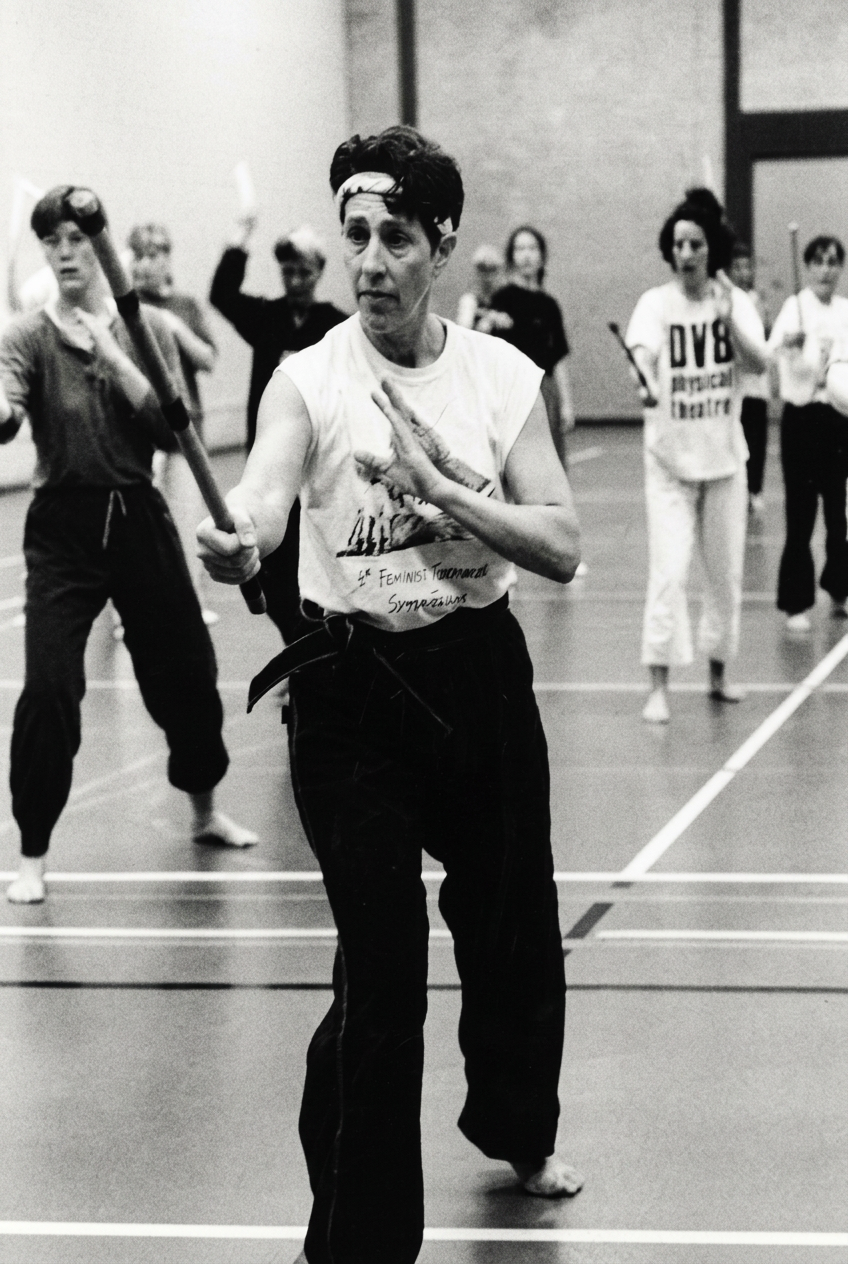 Beth Holt, Kawayan Martial Arts founder, leading a weapons training class with students practicing stick techniques