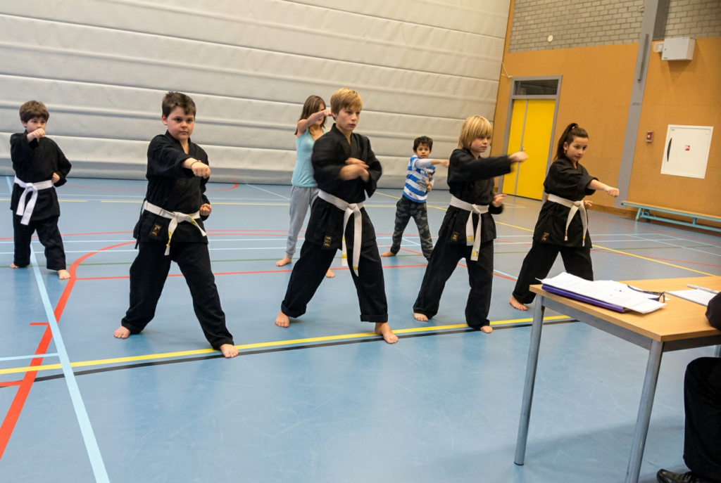 Children in white belts performing opening bow in Shuri Ryu Karate class, Kawayan Martial Arts School Gemert