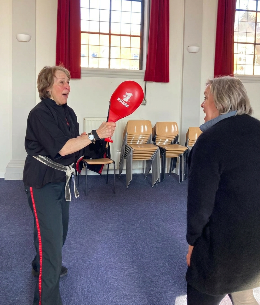 Beth Holt demonstrating self defense technique with striking pad during Kawayan Martial Arts School workshop