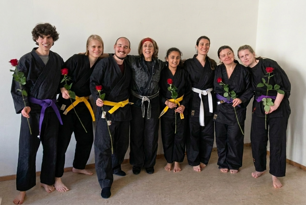 Beth Holt with Kawayan Martial Arts School students celebrating belt grading, holding red roses, Netherlands